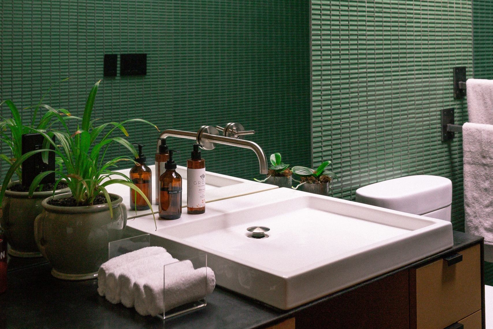baño renovado con azulejos verdes para un estilo diferente. Magnus Reformas